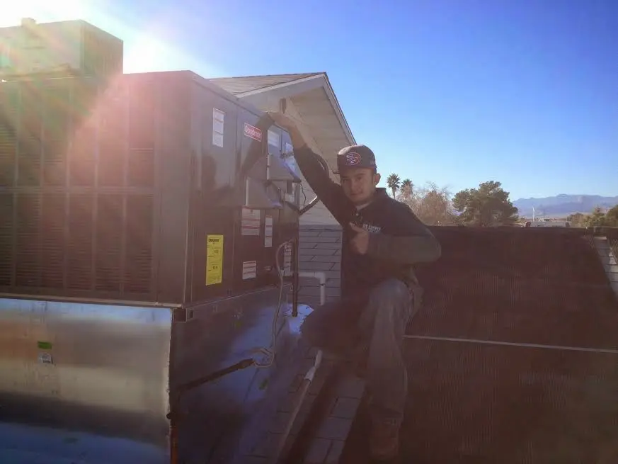 HVAC technician performing AC Tune-Up on a rooftop unit in Calexico